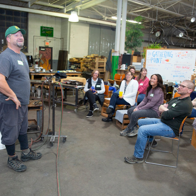 Chris, co-founder and co-owner of the Glass Academy, speaks with gleeful Breath of Michigan class students.