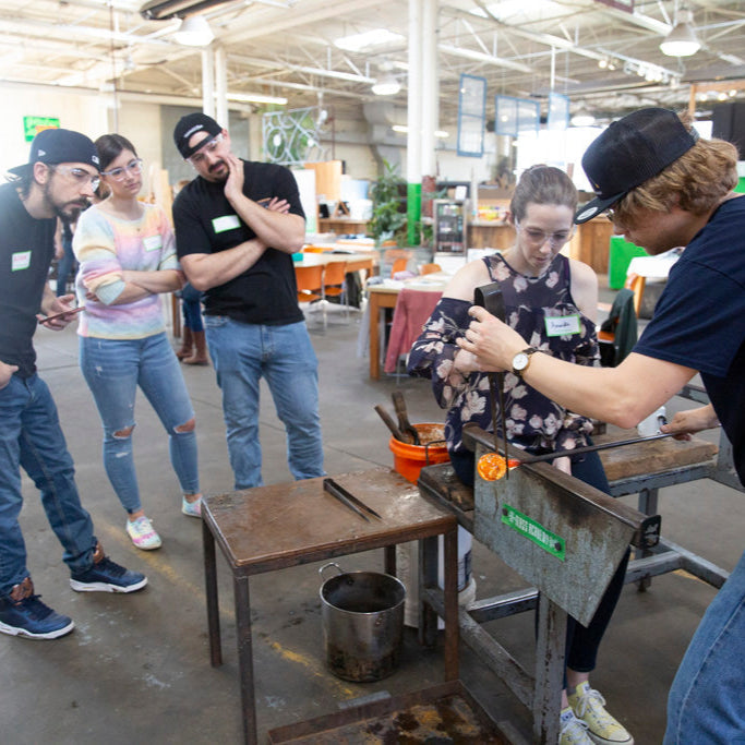 Our glassblower, Jake, helps a student perfect the shape of her Meditation Globe.