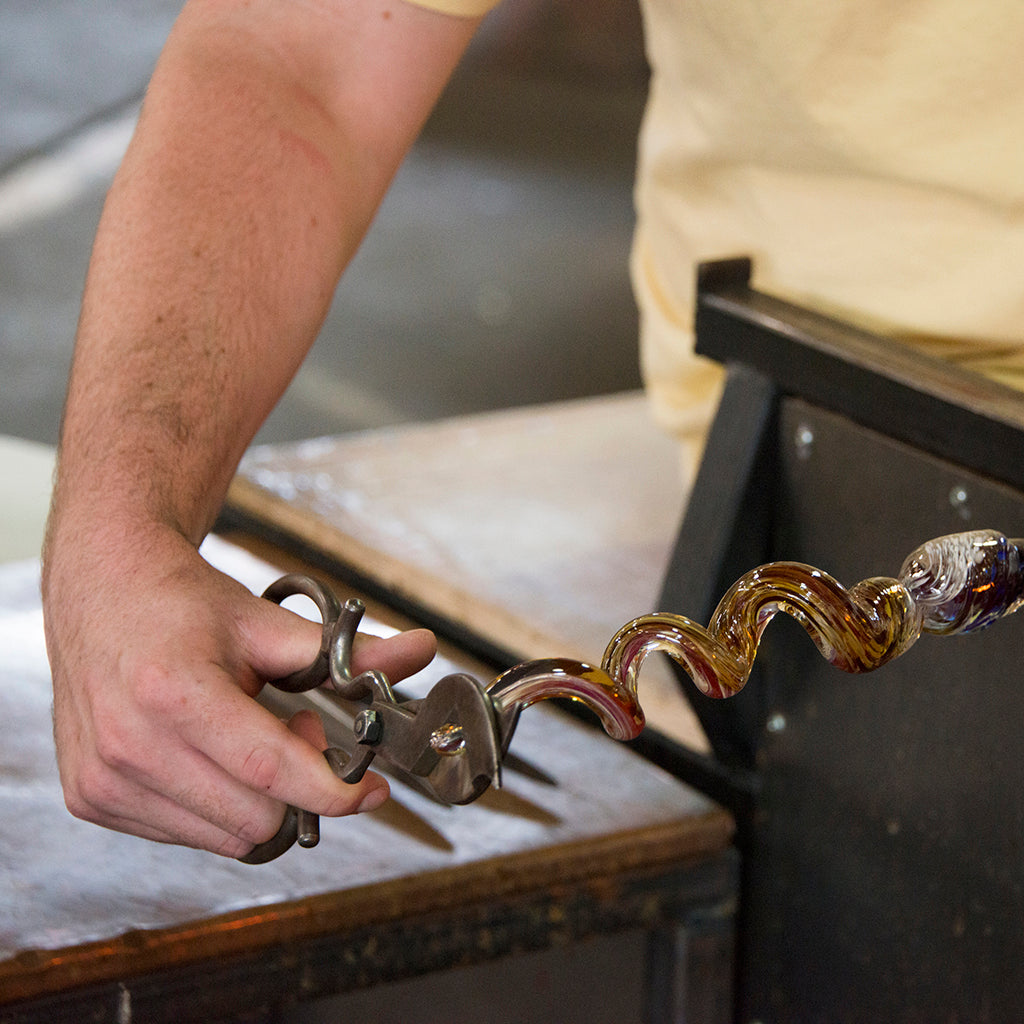 A student in the Percolla Reed class uses scissors to clip the end of their Percolla Reed.