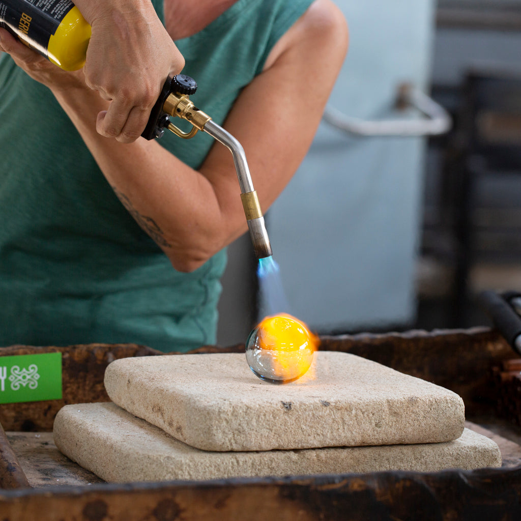 A Breath of Michigan class student fires their bubble with a blowtorch.