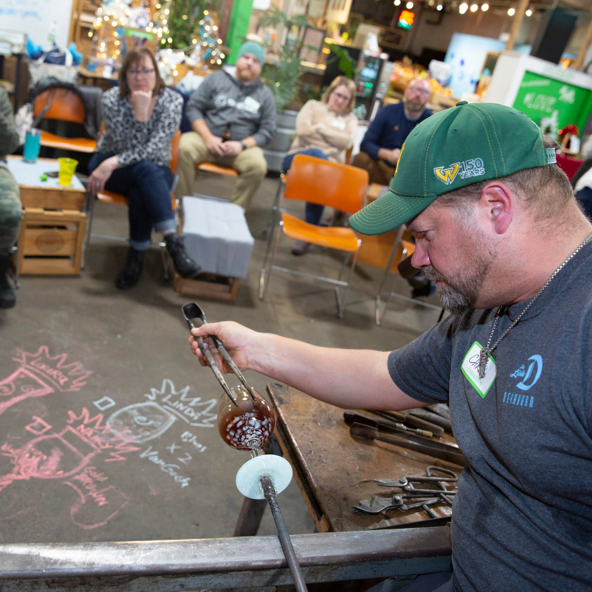 Chris, the co-founder and co-owner of the Glass Academy, intensely focuses while creating a Happy Hour class participant's custom wine glass.