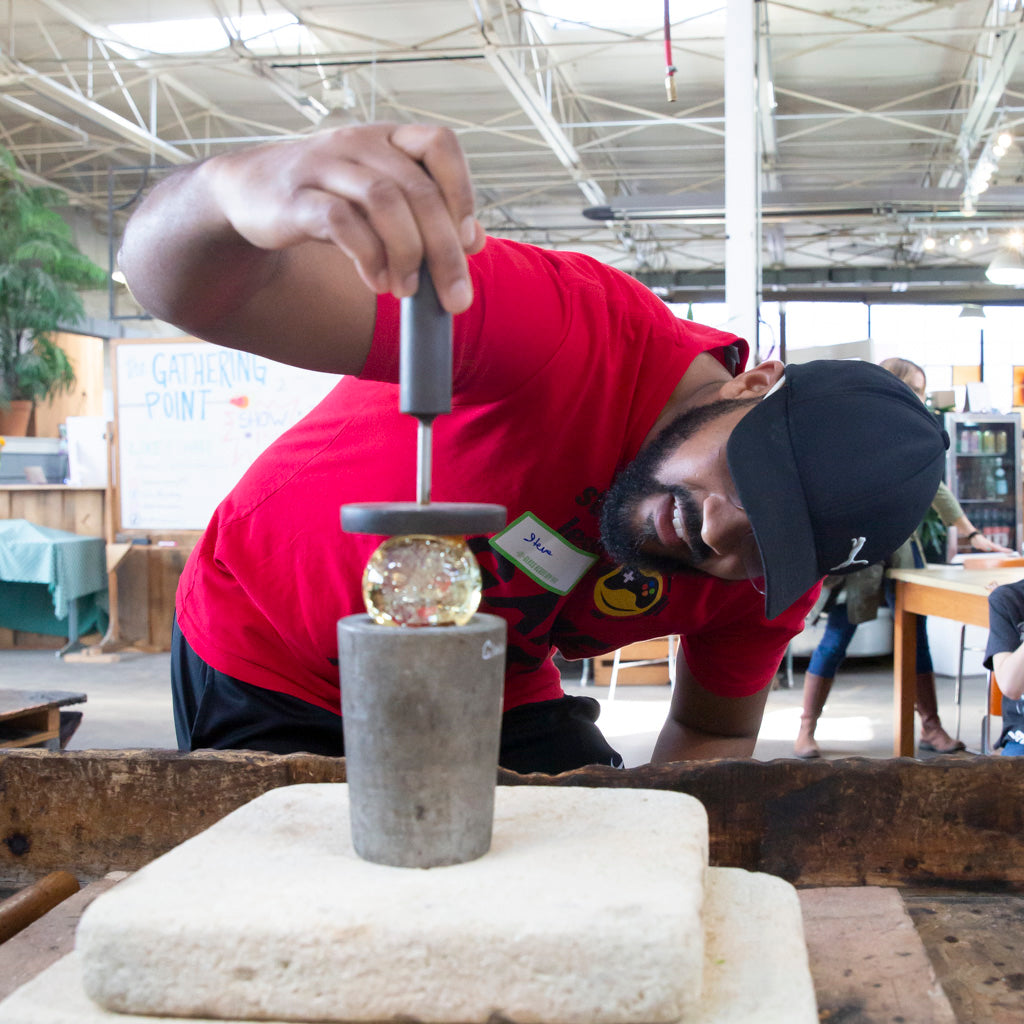 A Meditation Globe class student carefully flattens the base of his globe.
