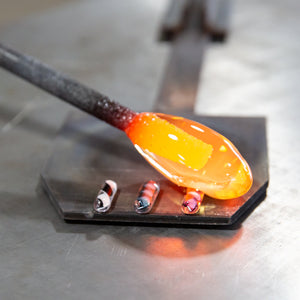 "twisties" of glass color are added to a gather of molten glass on the punty 